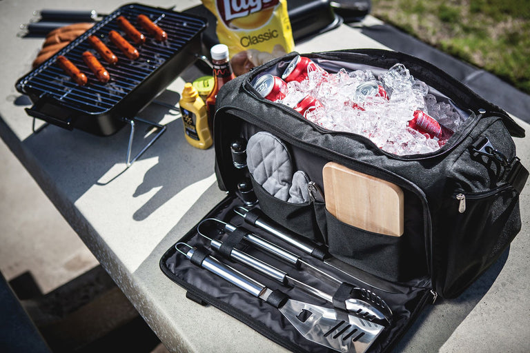 Grill bag containing hot dogs, BBQ tongs, and various grilling accessories for outdoor cooking.