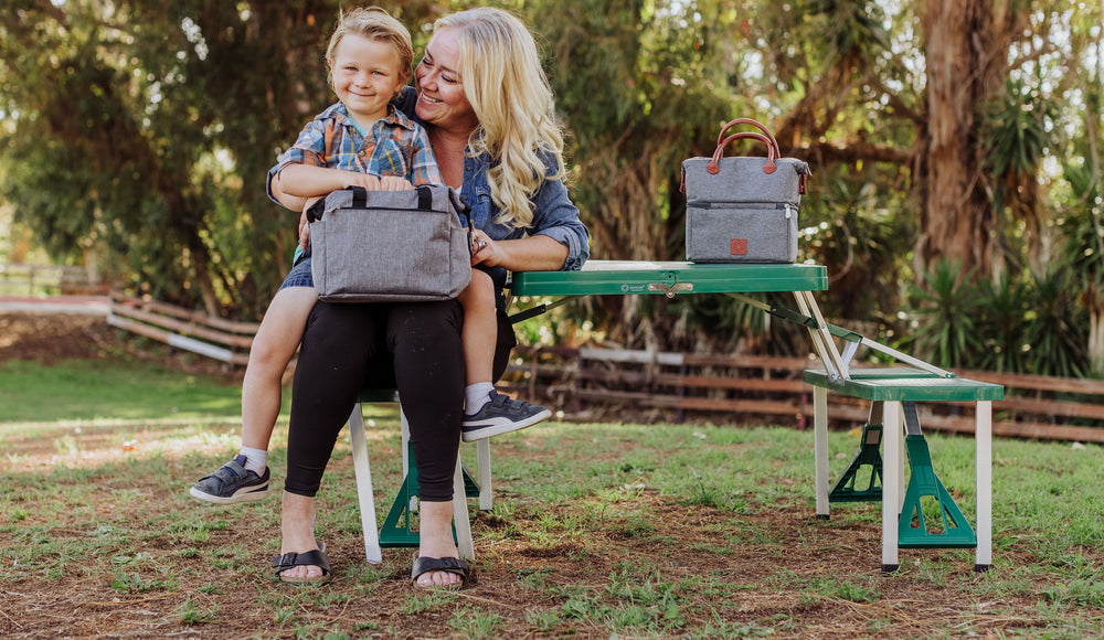 mom and son sitting at collapsible picnic table with lunch totes