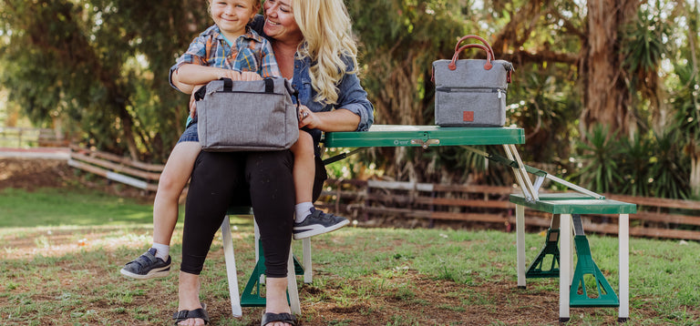 mom and son sitting at collapsible picnic table with lunch totes
