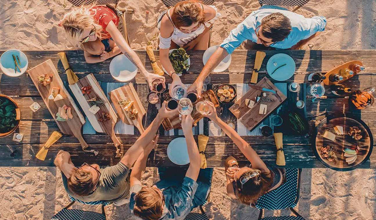 Group gathered around a picnic table sharing a meal using Picnic Time products